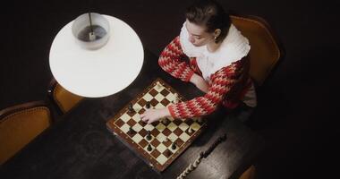 A woman playing chess on a table photo