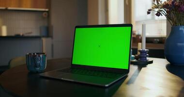 A laptop with green screen on a table photo