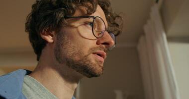 A man with glasses looking out the window photo