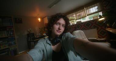 A woman with headphones on taking a selfie photo
