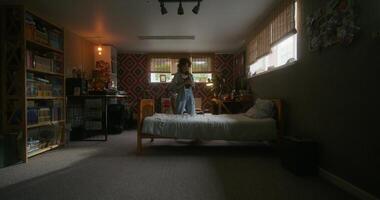 A woman standing in a bedroom with a bed and a desk photo