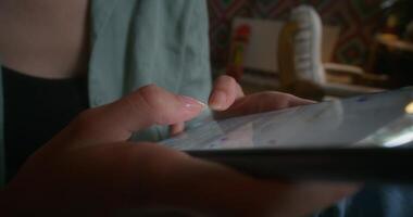 A person holding a tablet computer with a finger on the screen photo