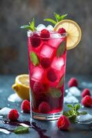 A refreshing raspberry drink garnished with lemon and mint, served over ice. photo