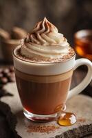 A beautifully layered coffee drink topped with whipped cream and cocoa, served in a clear mug. photo