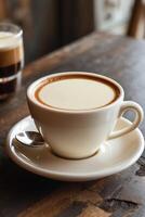 A cup of coffee with creamy foam, resting on a wooden table, inviting for a warm drink. photo