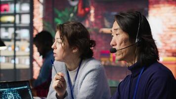 Call center manager supervising work done by agent helping customers regain access to accounts. Customer center supervisor overseeing employee assisting clients needing help, camera A video