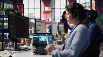 Worker providing live chat support, typing on keyboard, using AI chatbot to handle clients complaints. Call center agent dealing with unsatisfied customers using artificial intelligence LLM, camera B video