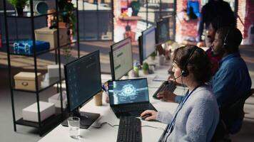 Technical support specialist in call center office doing troubleshooting helped by artificial intelligence tech. IT worker fixing customer connectivity issues using AI LLM chatbot, camera B video