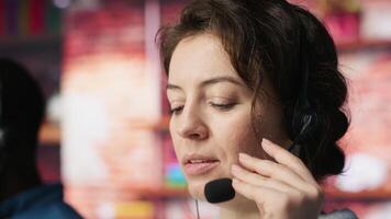 Close up of customer support workers listening to clients problems using headphones. Call center agents in office using headset microphone to provide information, solving customers concerns, camera A video