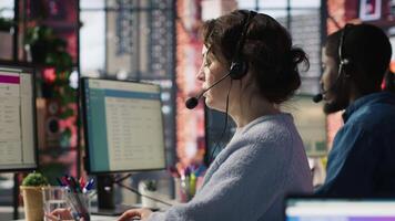 Account manager in office talking in headset mic, maintaining strong client relationships through regular communication. Employee talking with customer, Identify new sales opportunities, camera A video