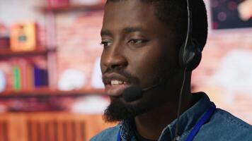 Closeup of call center agent using headphones mic to talk with customers, helping regain access to accounts. Customer center worker speaking in microphone, assisting clients needing help, camera A video