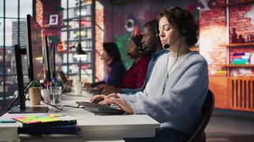 Account manager in office talking in headset mic, maintaining strong client relationships through regular communication. Employee talking with customer, Identify new sales opportunities, camera B video