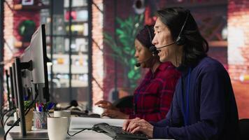 Experienced call center employee listening to customer inquiries and complaints. Asian senior customer service representative assisting customers with issues related to products or services, camera A video