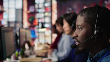 Call center agent providing support, handling clients complaints, speaking in audio headset mic. Employee dealing with unsatisfied customers, talking in headphones mic, camera B extreme close up video