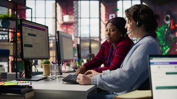 Account manager supervising work done by employee talking with customers to identify sales opportunities. Supervisor overseeing agent in office bonding with client to generate leads, camera B video