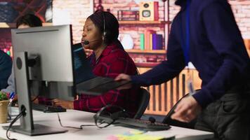 Call center senior engineer arriving at work, using AI, helping customers regain access to accounts. Customer center technician at desk using artificial intelligence, assisting clients, camera A video