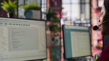 IT support expert at PC in call center office troubleshoots errors to minimize downtime. Tech support agent at desk writing code, maintaining technical systems and infrastructure, camera A video