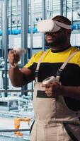 Vertical Smart factory expert using VR headset to test automated systems and ensure reliability. Worker virtual reality tech to identify bottlenecks and optimize gear based on sensors data, camera A video