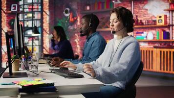 Happy call center employee working on PC, doing account management in office. Cheerful customer support agent handling inbound calls, assisting customers with inquiries, camera B close up video