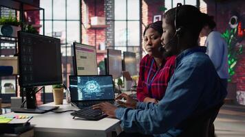 Call center manager teaching intern how to use AI to enhance customer interactions. Team leader in customer service office explaining trainee how to use artificial intelligence, camera B video