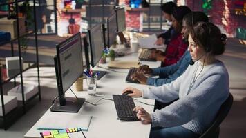 Customer support workers assisting clients to meet outbound call quotas and sales targets. Call center agents contacting prospects to inform them about new products, camera B video