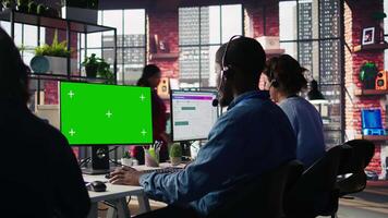 Call center agent using mockup green screen PC, providing step by step guidance to customers. Happy customer center worker using chroma key computer, diagnosing problems for clients, camera B video