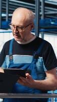 Vertical Supervisor overseeing work done by engineers in industry 4.0 solar panels plant to reduce downtime. Photovoltaics smart factory manager tasking workers with fixing damaged IoT sensors, camera A video