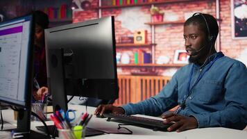 Customer support worker has conversation with client in live chat, providing solutions. Call center agent assists customers through digital communication channels, answering questions, camera B video