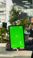Vertical Close up of green screen tablet in front of employee checking progress done on project. Chroma key device next to office clerks reading data statistics on PC screen, camera B video