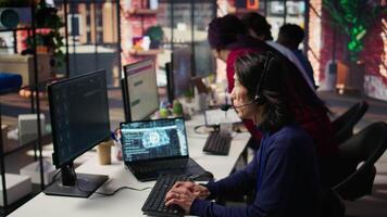 Call center agents track shipments in office using AI chatbot for help. Customer center workers use artificial intelligence assistance to locate clients packages and provide status updates, camera B video