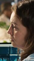 Vertical Stressed employee at office desk feeling tired while editing documents on computer. Overworked woman exhausted after inputting data in workplace at PC all day, feeling fatigue, camera A video