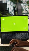 Vertical Mockup tablet and laptop in office used by employee working on company administrative tasks. Chroma key devices on desk used by worker reviewing business data metrics, camera A video
