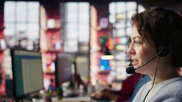Customer support workers listening to clients problems using headphones. Call center agents in office using headset microphone to provide information, solving customers concerns, camera B close up video