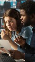 Vertical Manager at office desk next to accountant checking financial figures on documents, doing reports. Team leader and man working together crosschecking data on paperwork files, camera A video