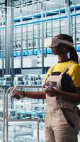 Vertical Photovoltaics smart factory technician fixing damaged IoT sensors using VR headset. Engineer in industry 4.0 solar panels plant using virtual reality find errors and reduce downtime, camera A video
