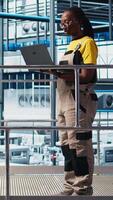 Vertical Smart photovoltaics factory engineering team looking at system performance metrics. Teamworking solar panels plant coworkers tracking energy production through IoT sensors, camera A video