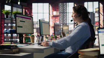 Call center agent handling inbound calls, assisting customers with inquiries, updating account records and meeting performance metrics in office environment, camera B close up video