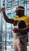 Vertical Engineer using virtual reality tech in industry 4.0 solar panels plant producing renewable energy. Technician in photovoltaics smart factory analyzing data using VR headset, camera A video