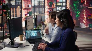 Call center manager supervising work done by agent helping customers regain access to accounts. Customer center supervisor overseeing employee assisting clients needing help, camera B video