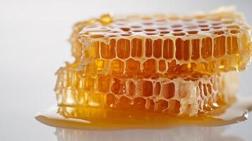 Close-up of golden honeycomb with dripping honey on a light background photo