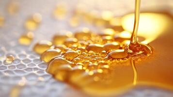 Golden honey pouring onto honeycomb surface creating textured pattern photo