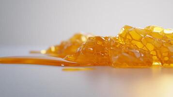 Golden honeycomb with dripping honey on a white surface photo