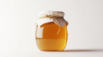 Rustic jar of honey with cloth lid and twine on white background photo