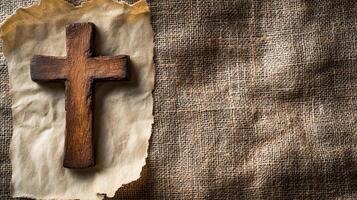 Rustic wooden cross on burlap background with parchment paper symbolizing faith and spirituality photo