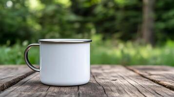 White metal mug on wooden table in natural outdoor setting photo