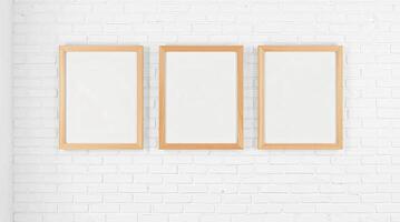 Three empty frames on a white brick wall photo
