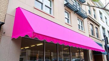 A bright pink awning is hanging over a store photo