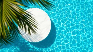 A white round table in a pool with palm trees photo