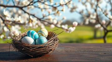 Easter eggs in a nest on a table with a tree in the background photo