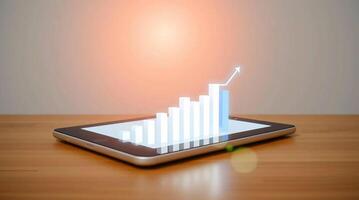 Tablet pc with graph on screen and light on table photo